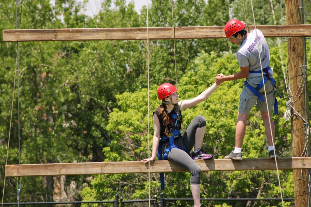 students helping each other on the challenge course
