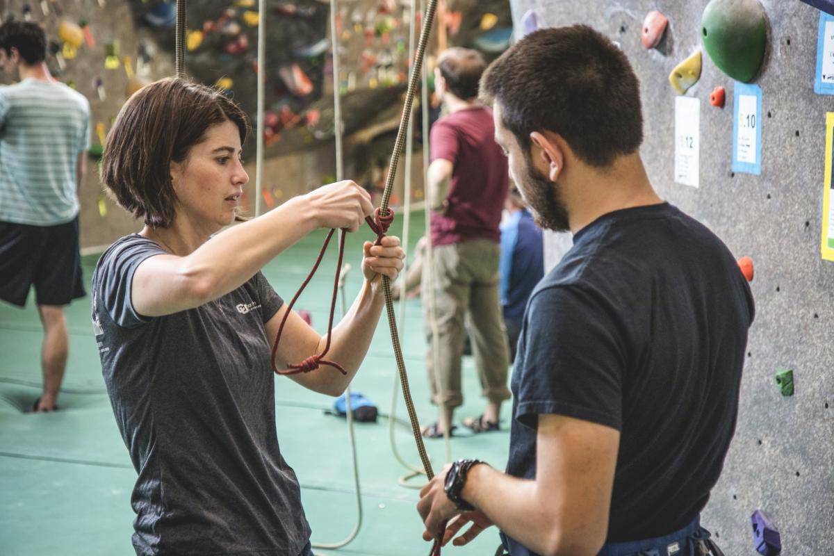 a student learning a knot in the climbing gym