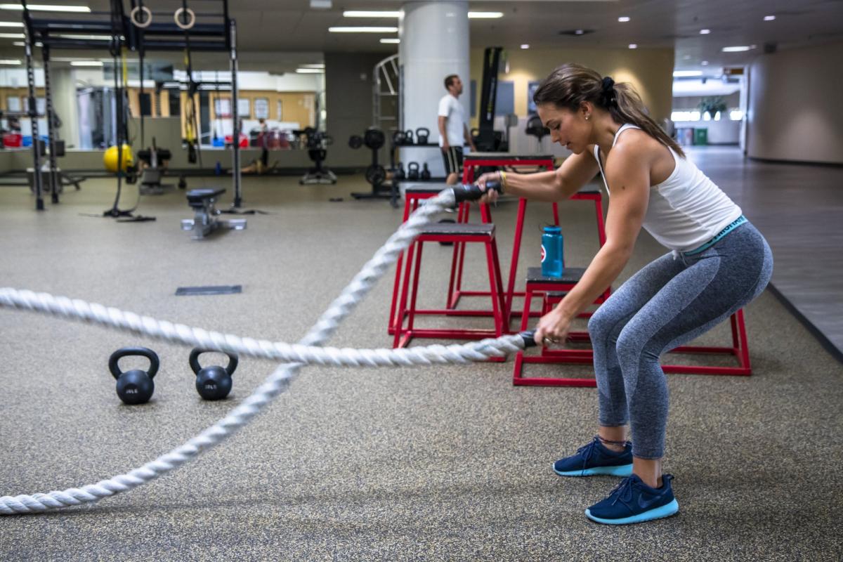 Female student using ropes in functional fitness area
