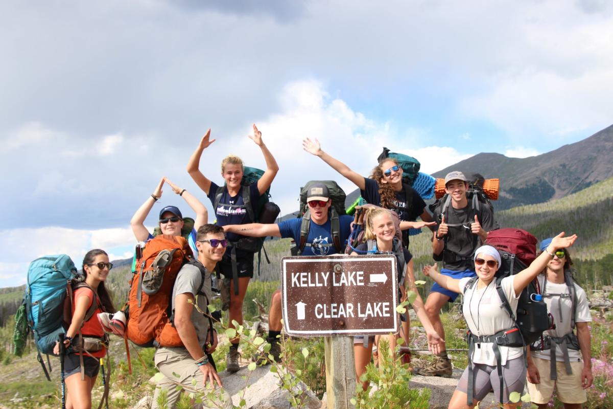 students pose by a sign