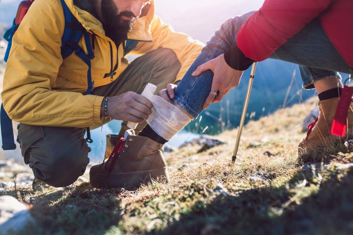 someone tying an ankle in the wilderness