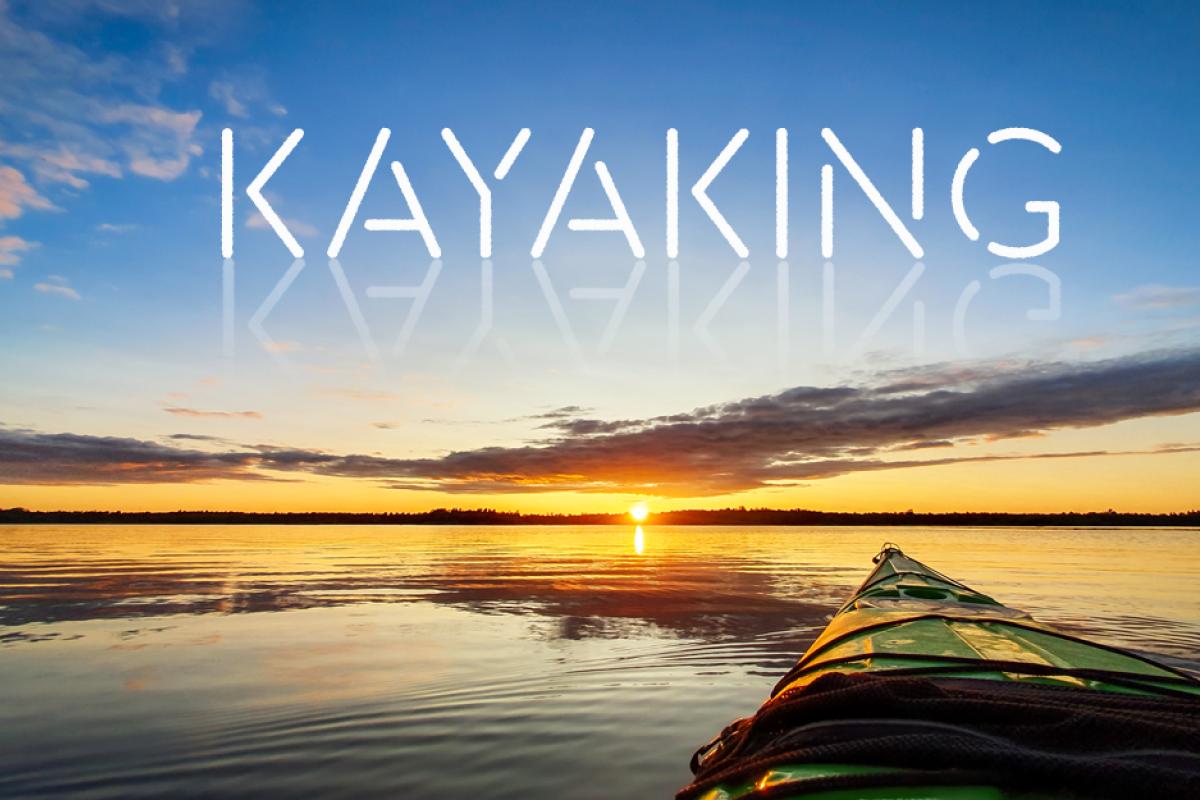 a kayak with the word "kayaking" written in the sky above it