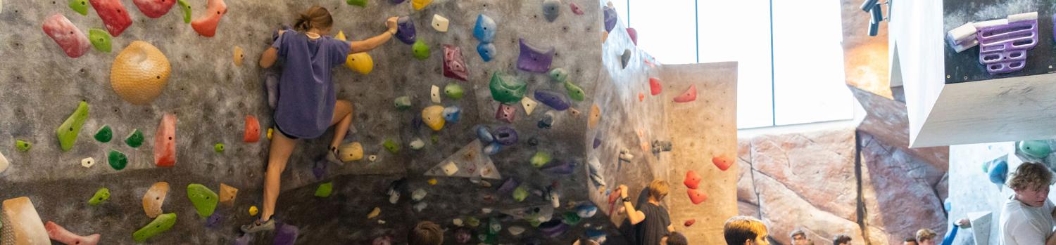 student on climbing gym wall