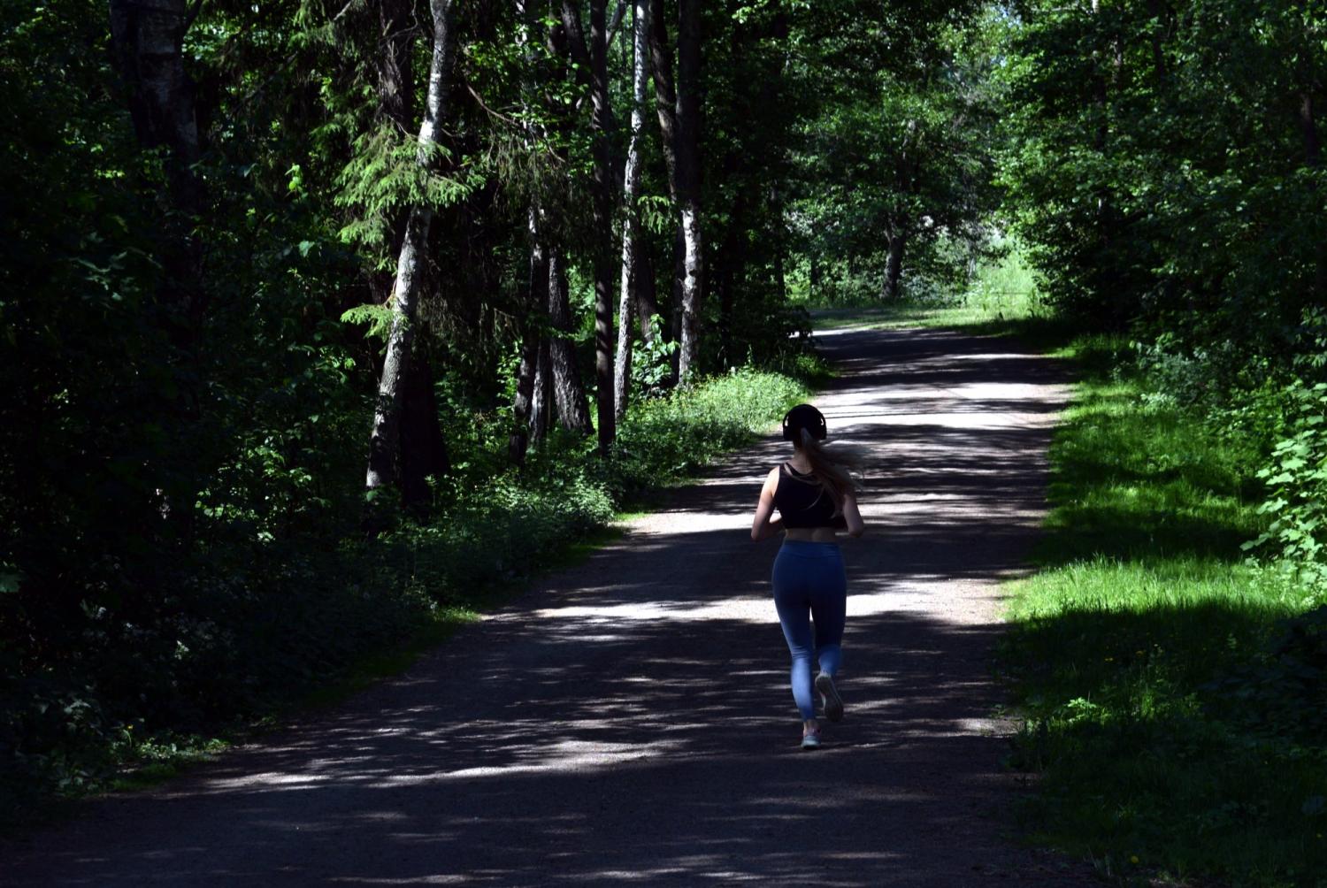 lone woman running through a trail in the forest