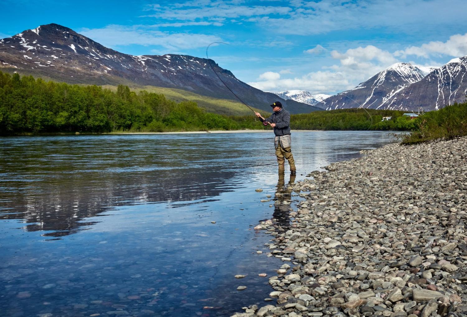 solitary man fly fishing in a lake
