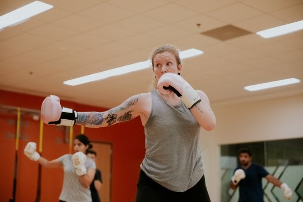 boxing instructor demonstrating movement in class setting