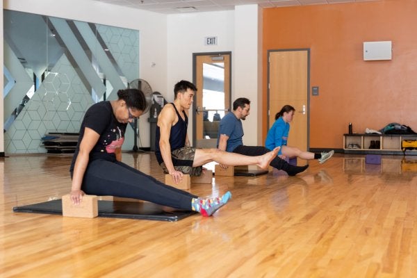 class participants balancing above the ground on blocks