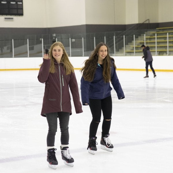 Two female students skating at the ice rink