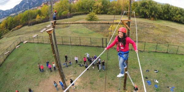 woman walking across ropes on the challenge course