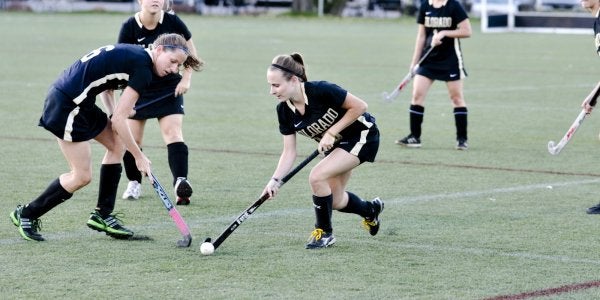 Students playing field hockey