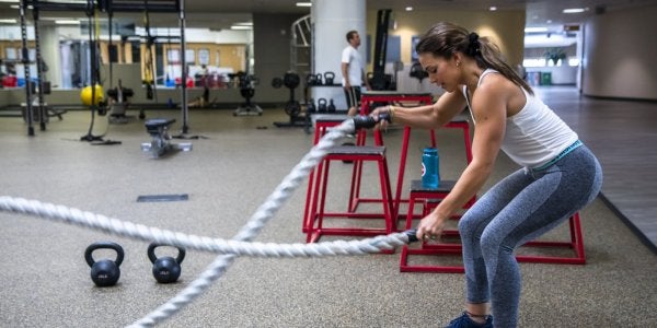 Female student using ropes in functional fitness area