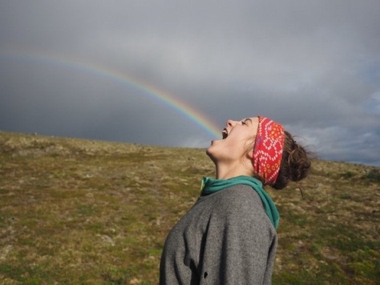 woman in a red bandana pretending a rainbow is coming from her mouth