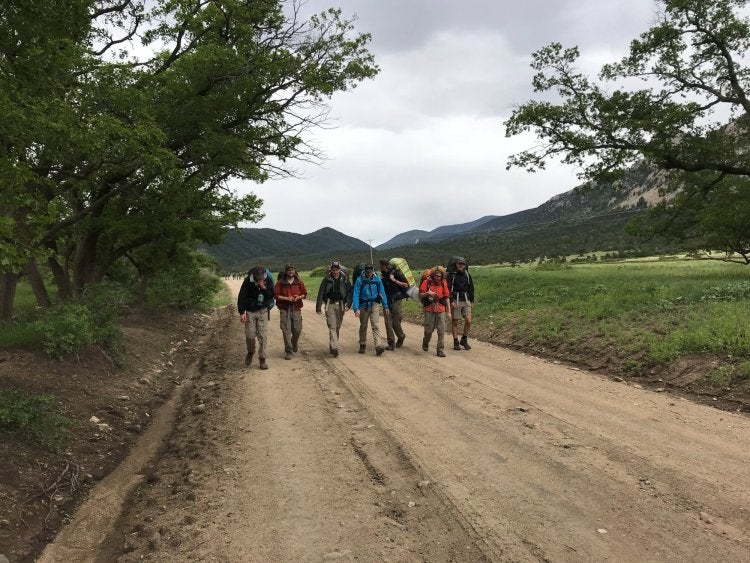 a group hiking down an open path