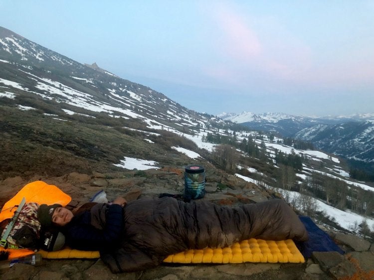 woman sleeping on the side of a mountain