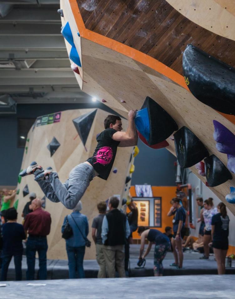 a man hanging low off a rock wall