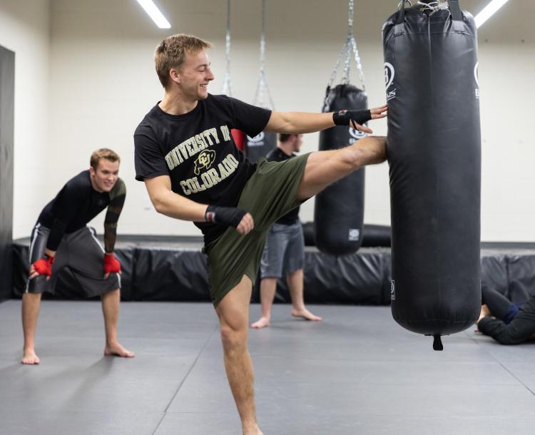 cu student kicking a punching bag