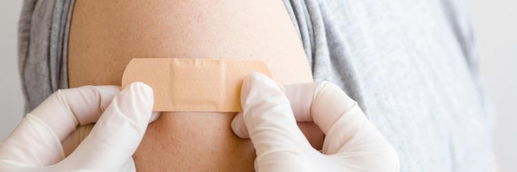 Doctor applying bandaid to shoulder