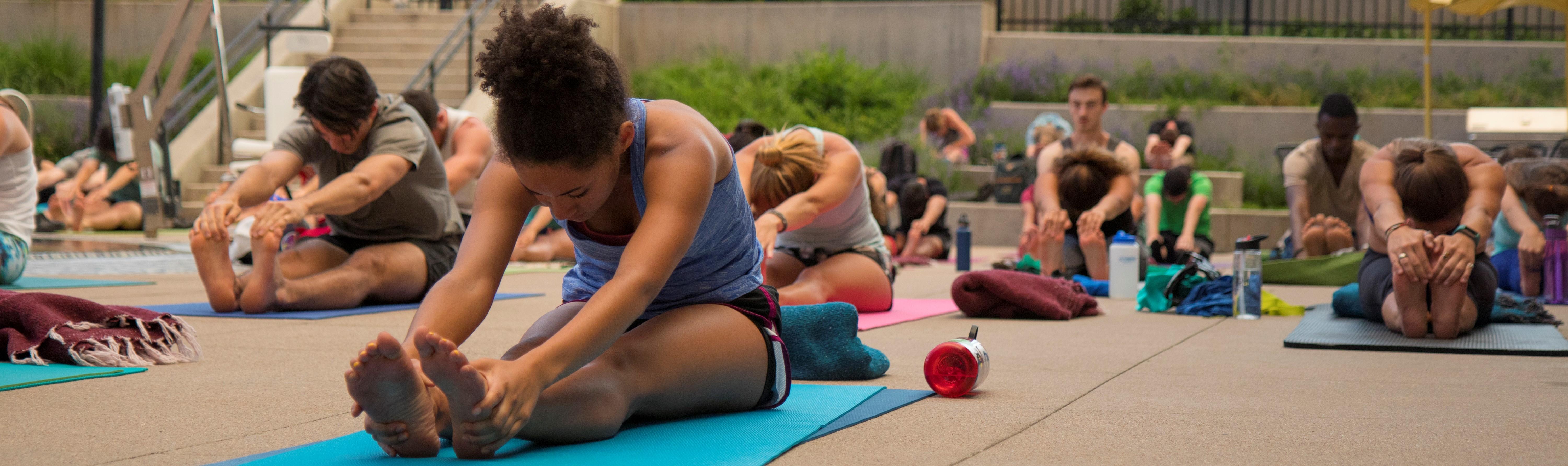 a large group doing yoga outdoors