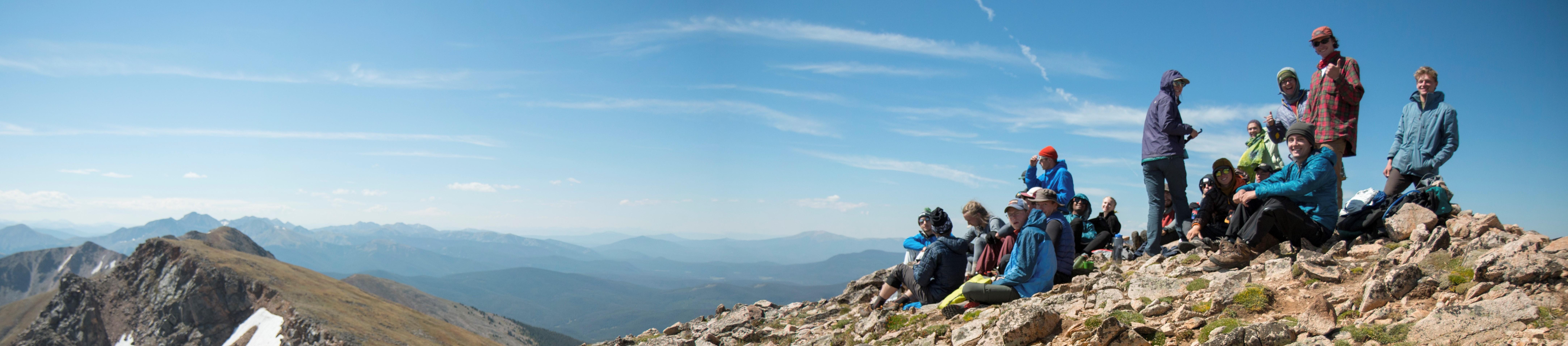 students sitting on top of a rocky mountain