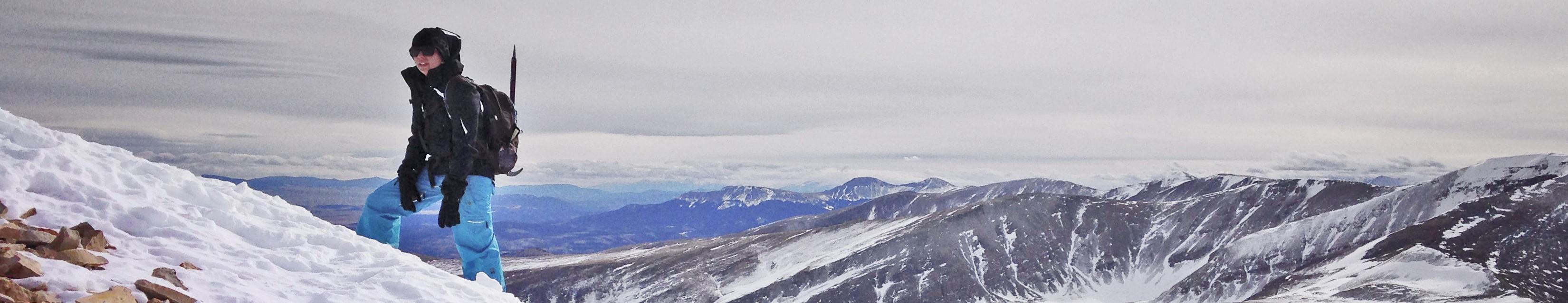 a lone hiker on a snowy mountain ridge