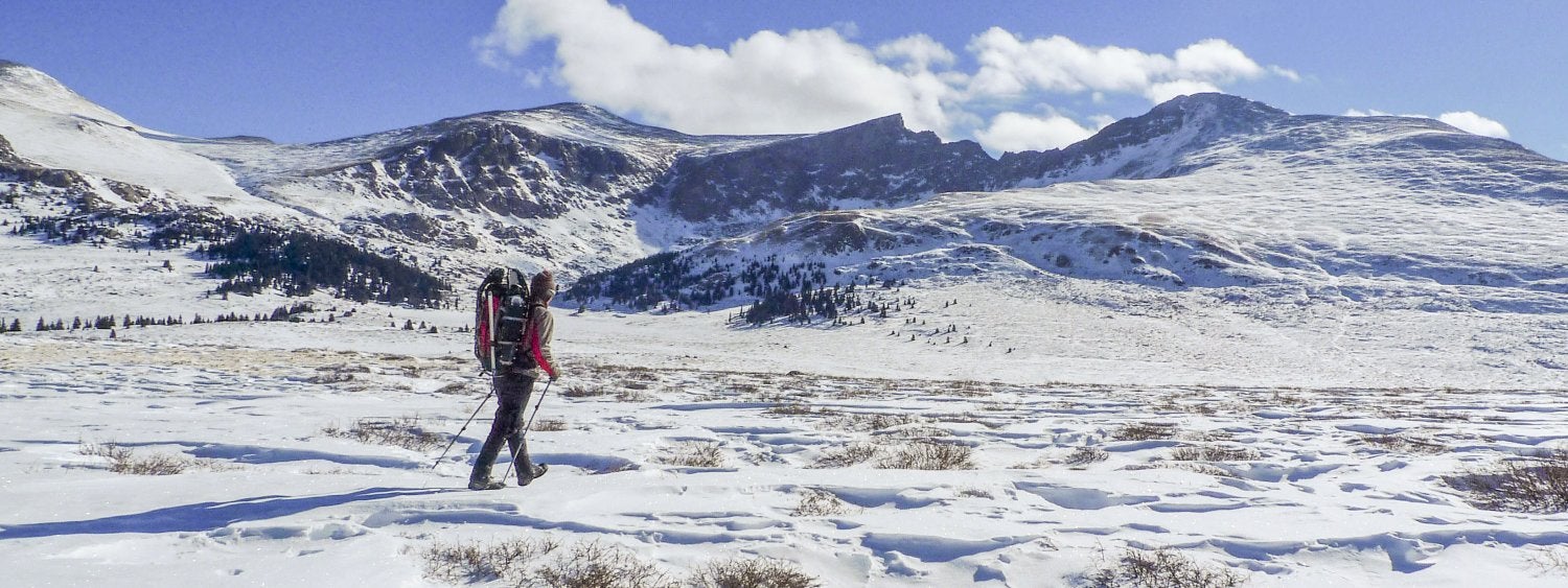 Hiker on snow covered trail on Mt. Bierstadt