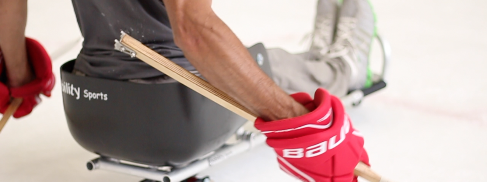 Person playing ice hockey using ice sled