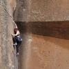 ella climbing up a sheer rockface
