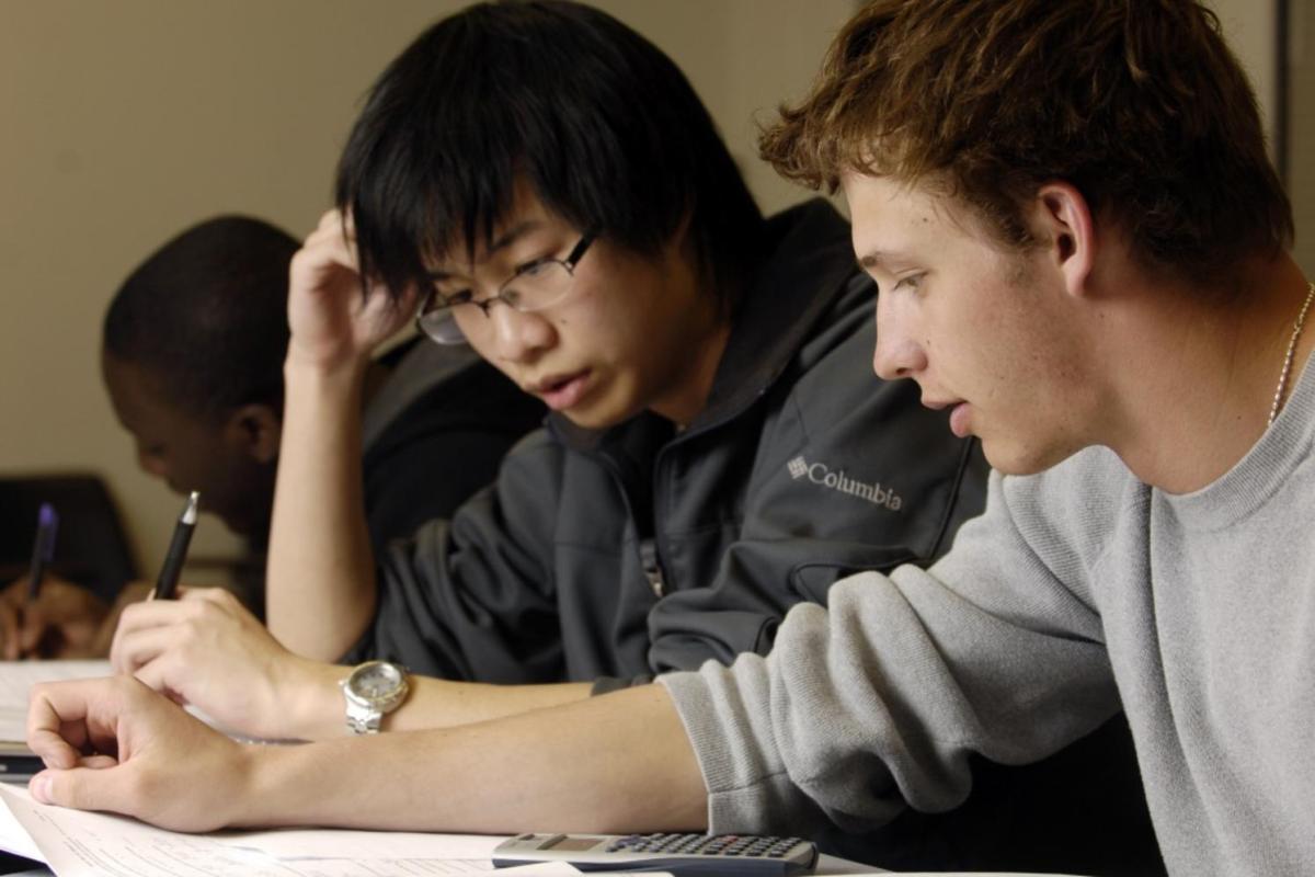 Two students work together on a written assignment.