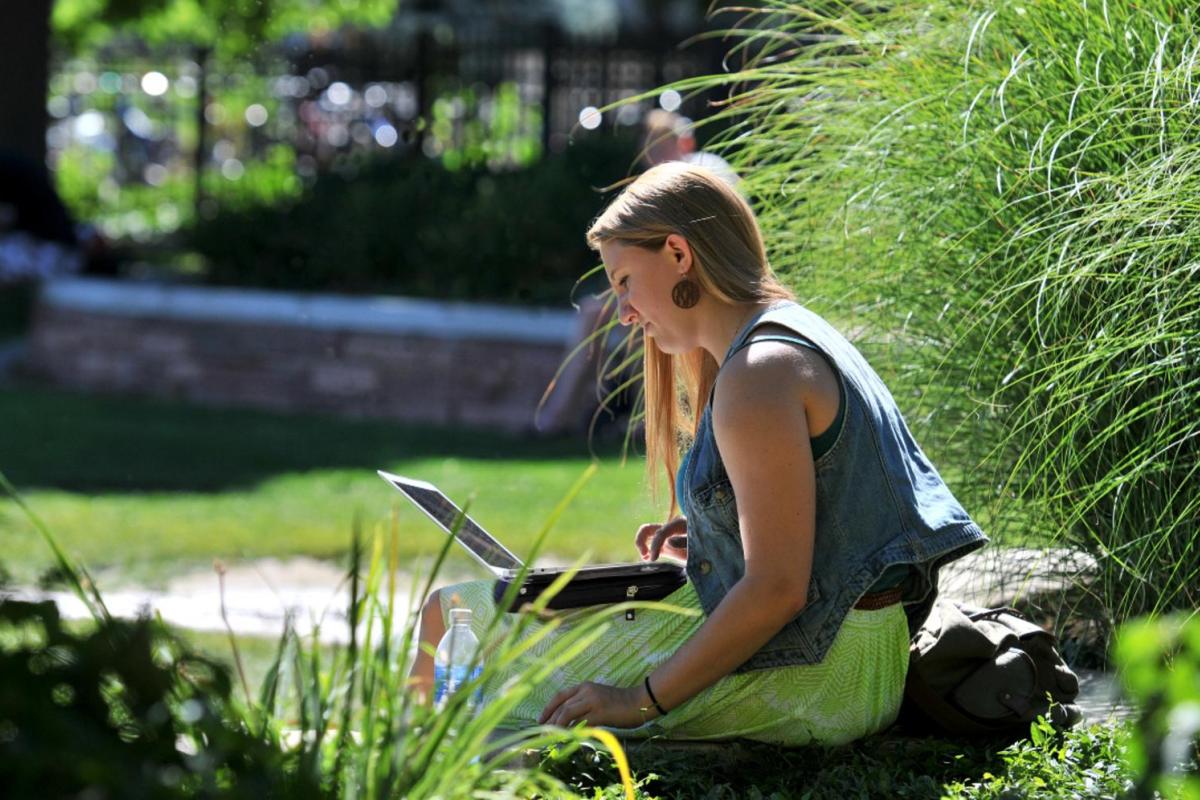 Female student using a laptop outside