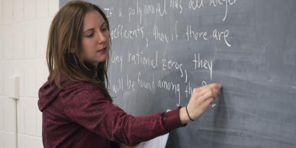 An instructor writing on a chalkboard.