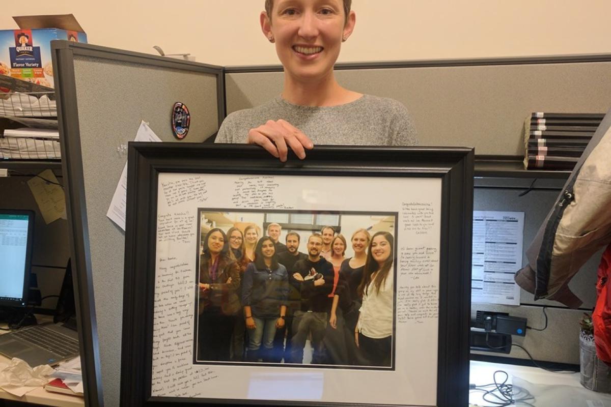 Keesha with a group picture in a frame with a lot of messages