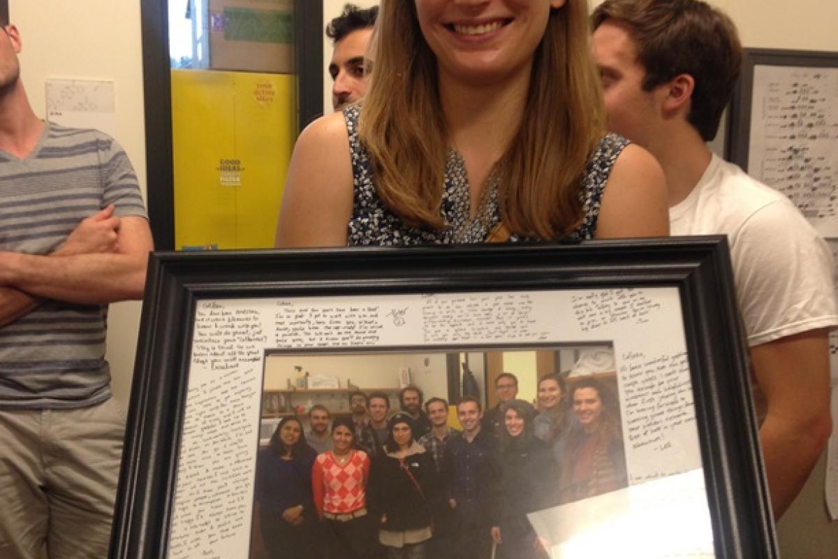 Colleen holding a team picture frame with a lot of messages