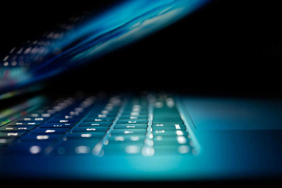 Partially opened laptop with blue light