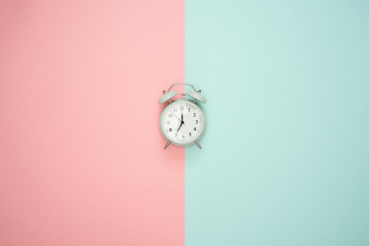 An alarm clock on colored background