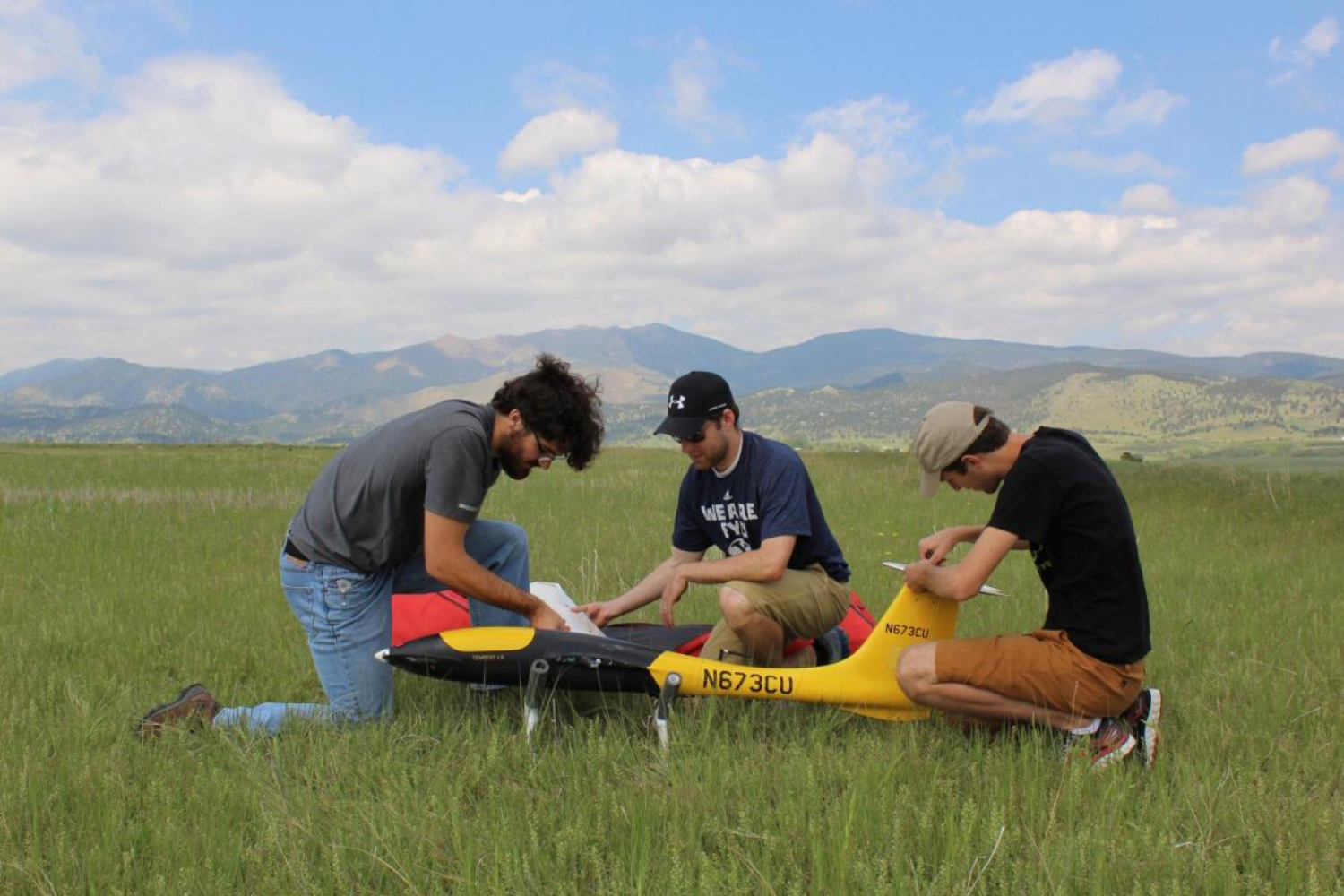 Students with IRISS adjust drones in the field