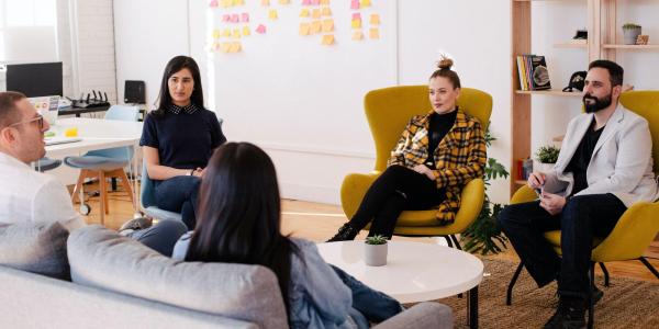 Group of men and women sitting in a circle in a meeting