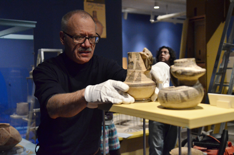 Researcher with Native American pottery in the Museum of Natural History