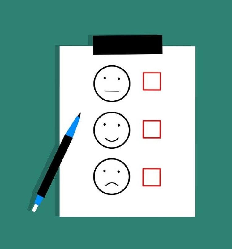 Illustration of paper with three smiley face ratings and check boxes.