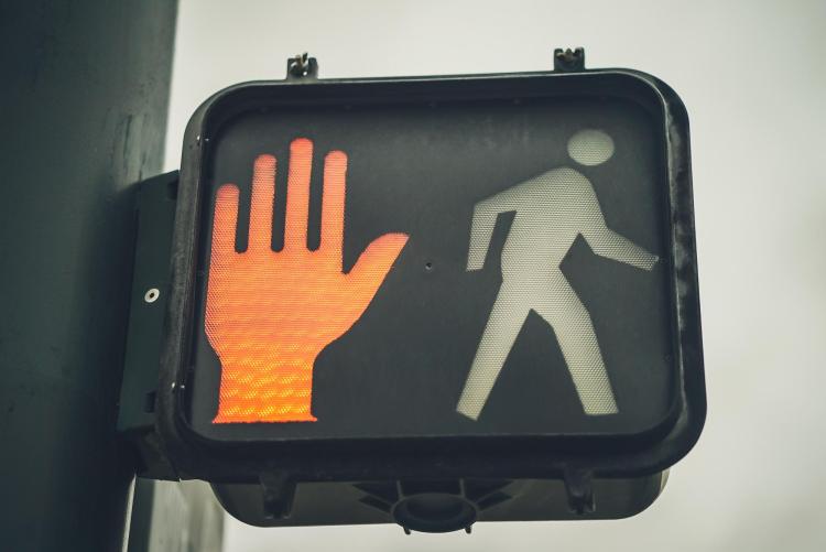 Traffic signal showing a hand for stop and a walking person