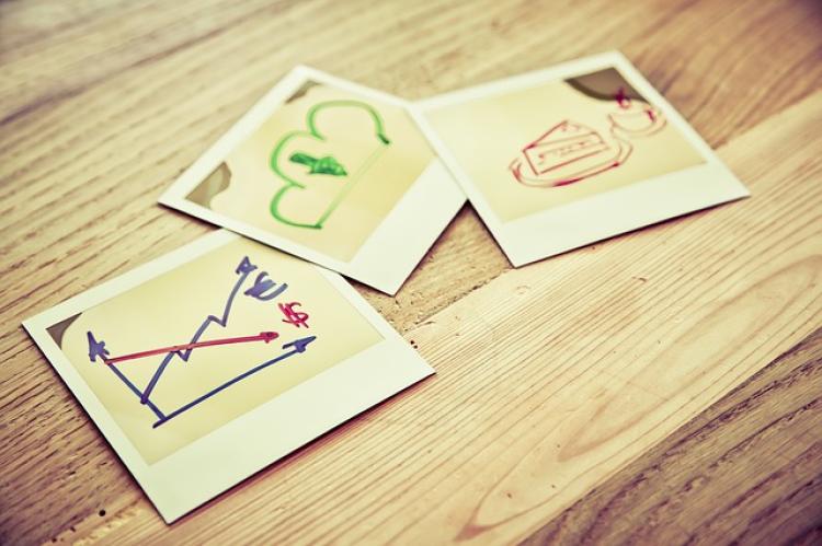 Three photographs on a table with illustrations of data and graphs.