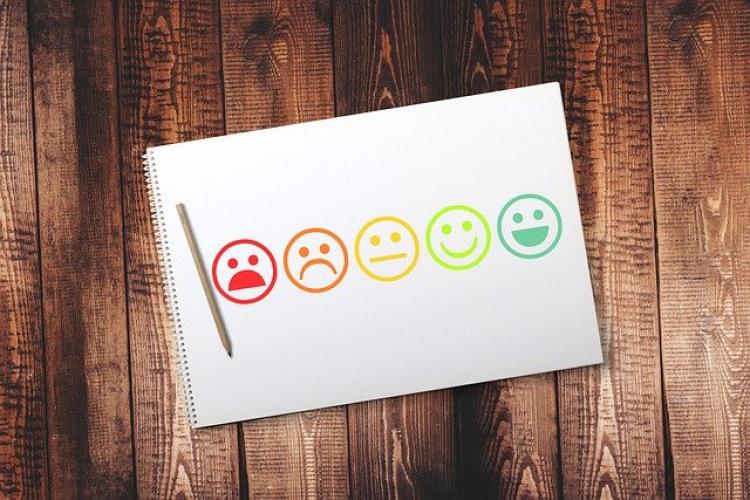 Sketchbook with drawings of faces with a range of emotions from frowning to smiling.