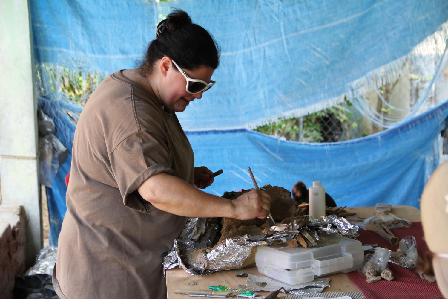 Arion Mayes working on a burial. / Arion Mayes limpiando un entierro