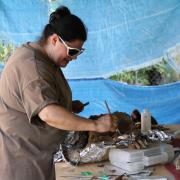 Arion Mayes working on a burial. / Arion Mayes limpiando un entierro