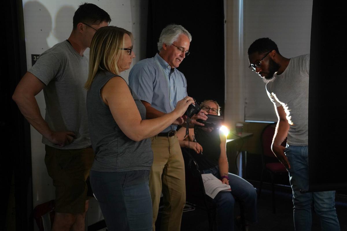 Student and teacher group uses a tool to learn about lighting