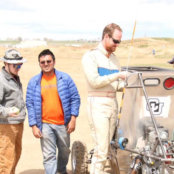 Bill, Coach, and Rishav working on the car
