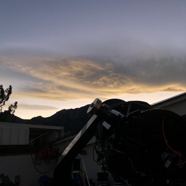 Photo from the view of the observing deck with a 20" PlaneWave telescope with cloud above the Flatirons