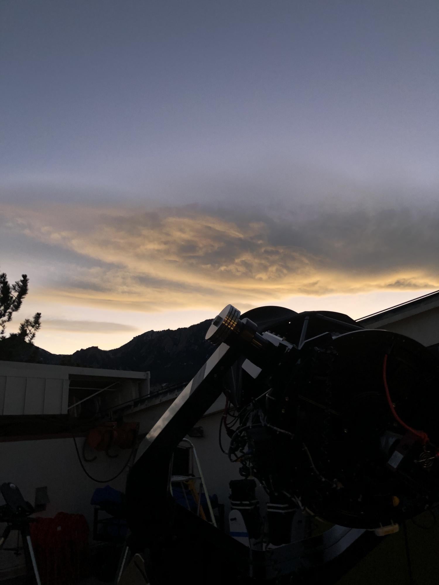 Photo from the view of the observing deck with a 20" PlaneWave telescope with cloud above the Flatirons