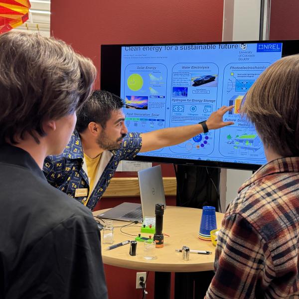 scientist speaking to 2 high school students