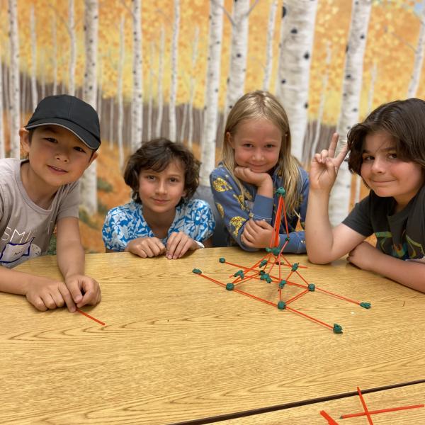 4 kids at table with project