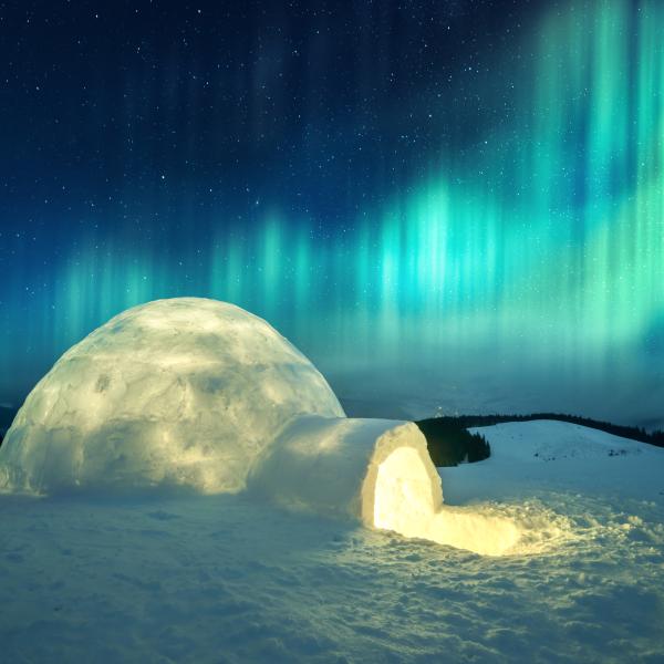 Aurora borealis/Northern lights in winter mountains with igloo